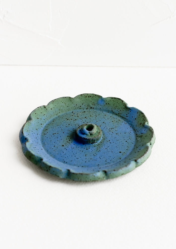 A flower shaped ceramic incense holder in blue/green glaze.