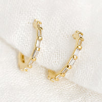1: A pair of gold hoops with clear baguette shape crystals.