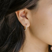 2: A pair of gold hoops with clear baguette shape crystals.