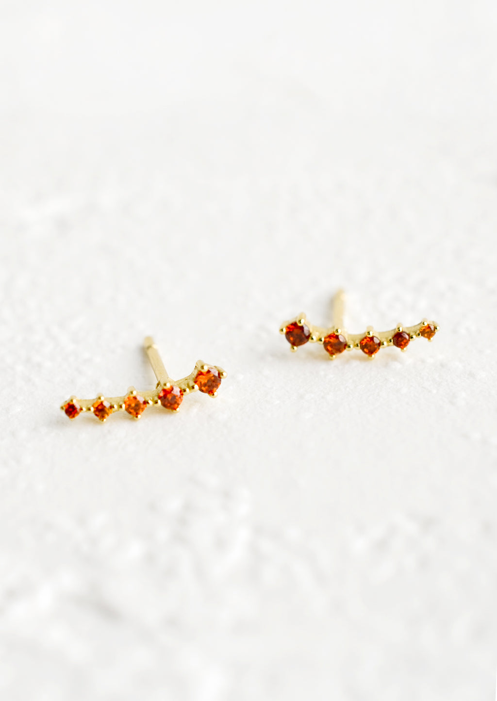 Amber: Stud earrings with amber crystals in incremental sizes, designed to climb up the ear