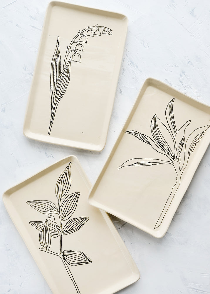 Rectangular ceramic trays in natural bisque color with etched black botanical drawings