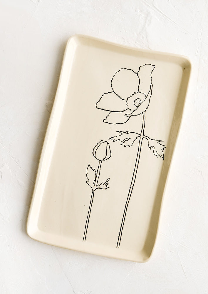 A rectangular ceramic tray in natural bisque color with an etched black drawing of anemone flower.