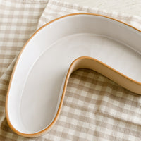 1: A boomerang shaped ceramic serving dish.