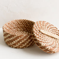 2: A small, round lidded basket made from woven pine needles.