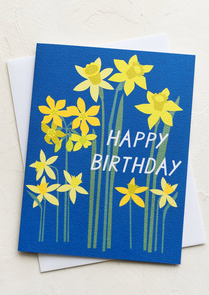 A blue card with yellow daffodil print, text reads "Happy Birthday".