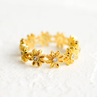 1: A gold ring made of flower shapes with crystal centers.