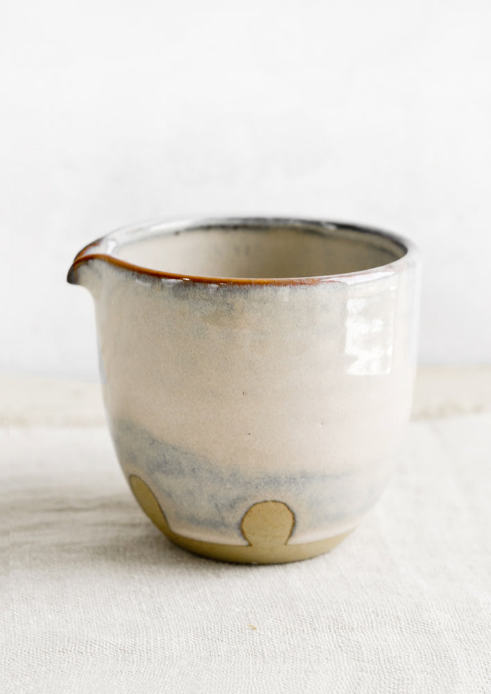 A small ceramic pitcher in mottled pastel glaze.