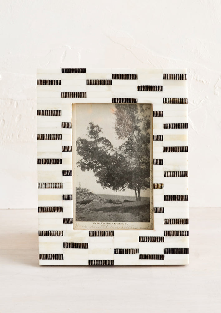 A tabletop picture frame in black and white dashes pattern.