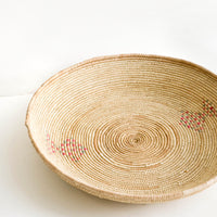 2: Woven platter made from date palm with pink and green design