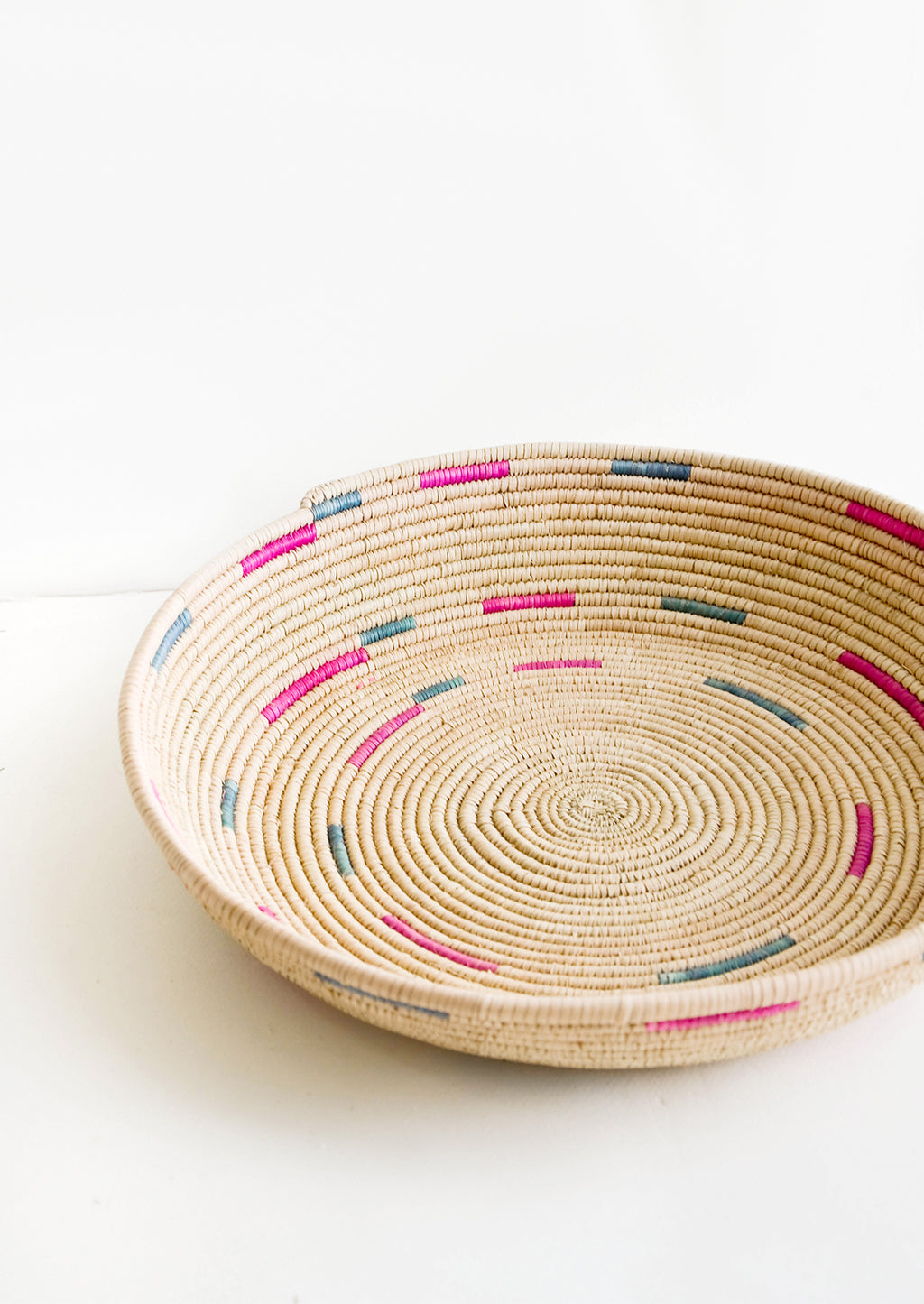 1: Woven platter made from date palm with pink and green design