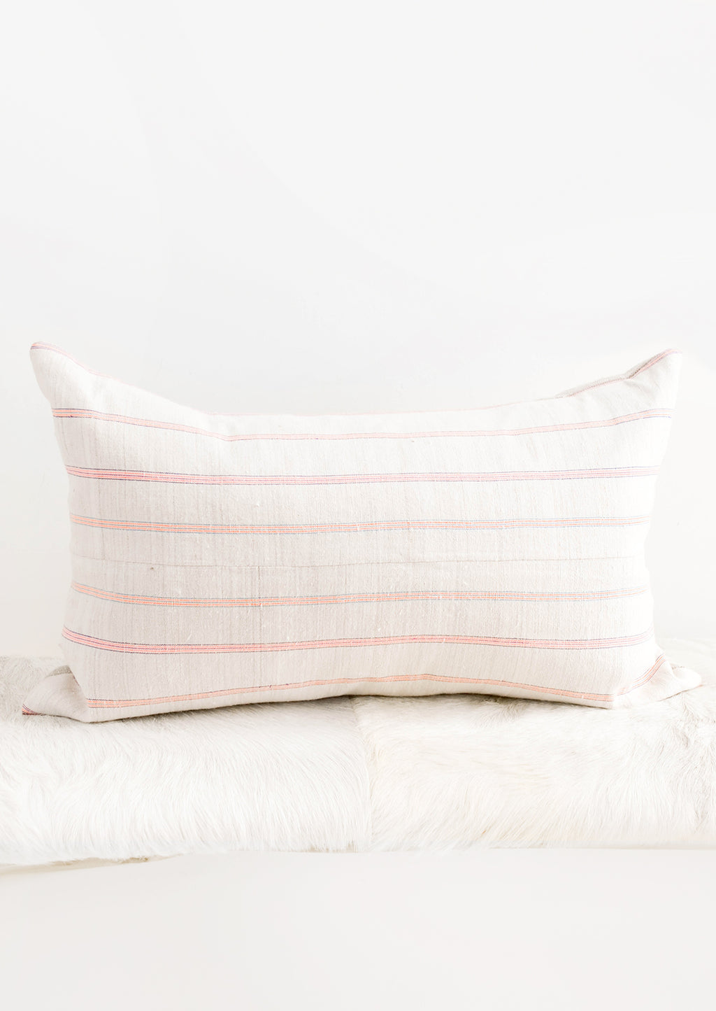 1: Rectangular throw pillow in light fabric with horizontal neon stripes