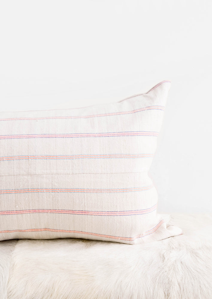 Rectangular throw pillow in light fabric with horizontal neon stripes
