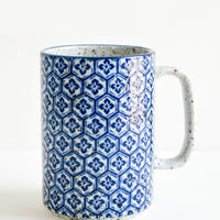 Hexagonal Floral: A tall mug with handle made from speckled grey ceramic with hexagonal indigo tile pattern throughout.