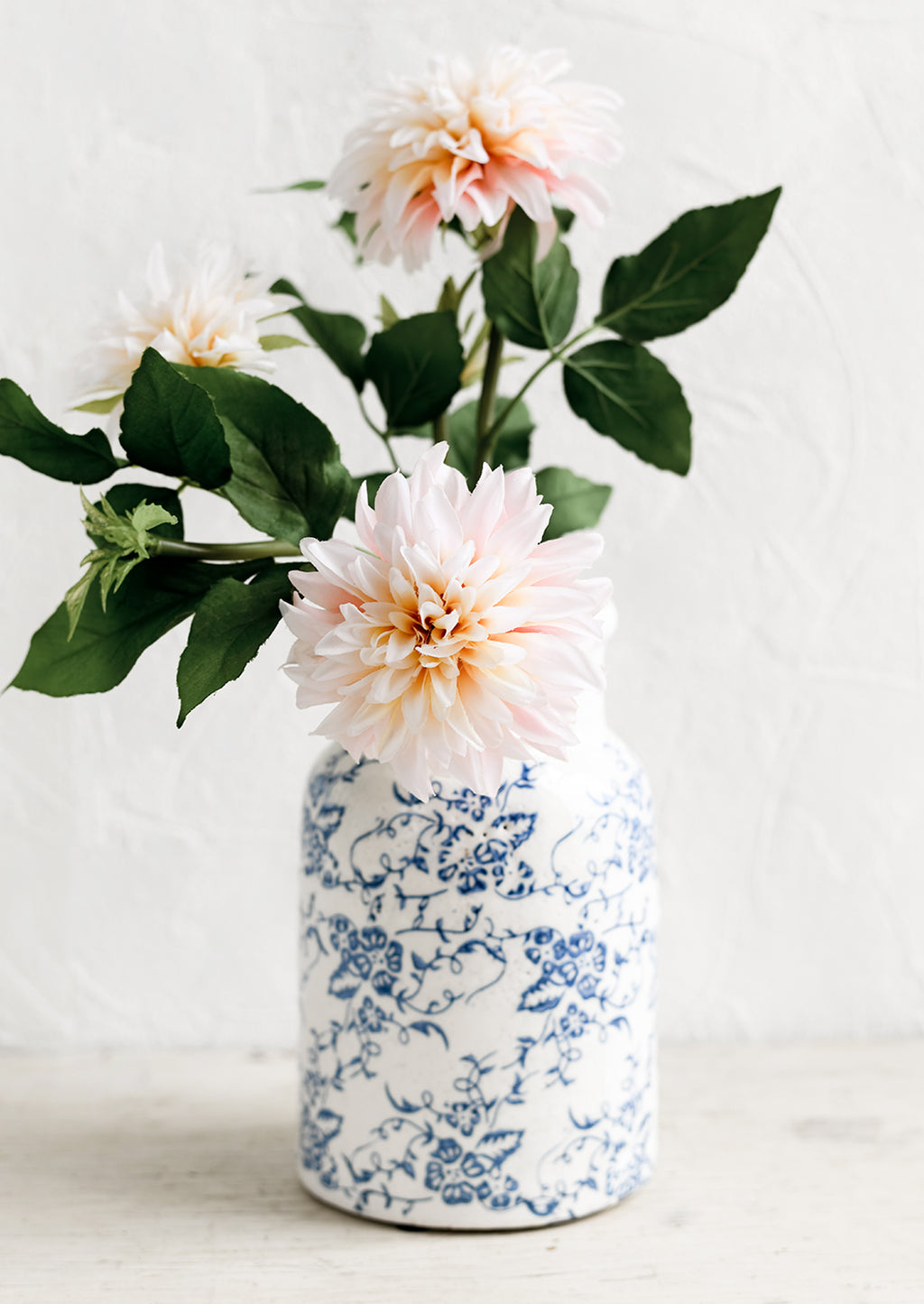 2: A blue and white ceramic vase with antique floral print, holding dahlias.