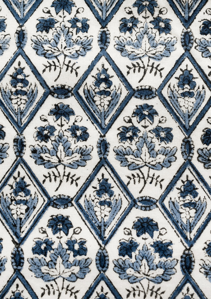 A block printed pillow in blue and white tile print.