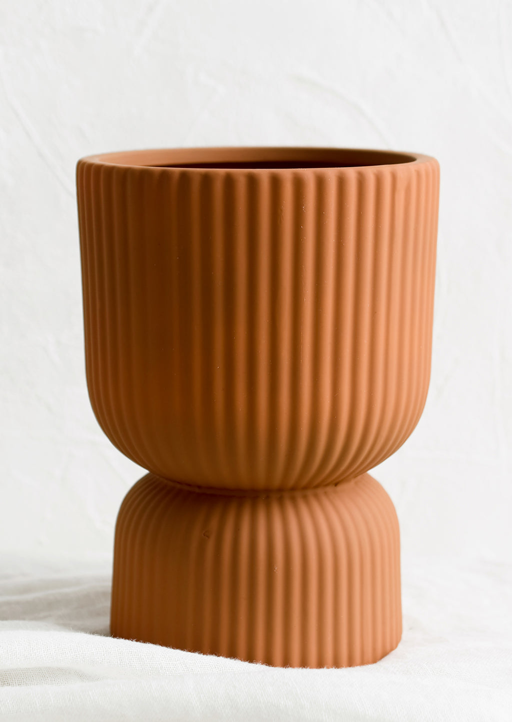Large / Terracotta: A terracotta colored vase/planter in curvy silhouette with pinched middle.