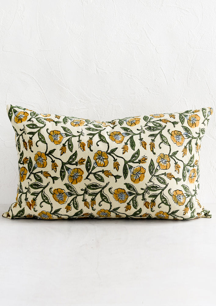 A lumbar pillow in beige, mustard, blue and green floral print.