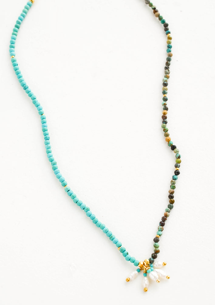 1: Beaded necklace with round turquoise stone beads, five freshwater pearls dangle at front and center