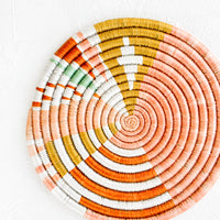 1: Colorful round trivet made from dyed raffia in a geometric pattern and pastel hues