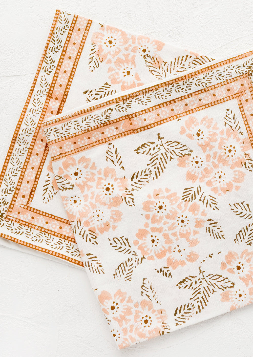 1: A pair of cotton napkins with peach and brown floral print.
