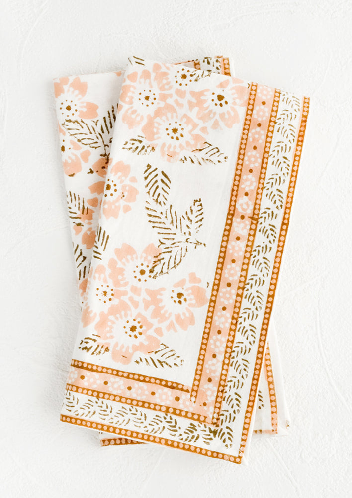 2: A pair of cotton napkins with peach and brown floral print.