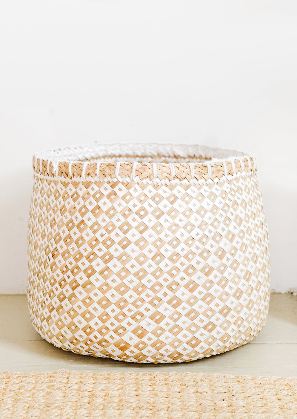 2: A round storage basket in natural straw and white paper.