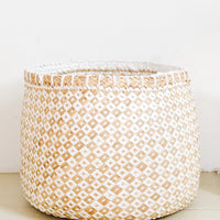 2: A round storage basket in natural straw and white paper.