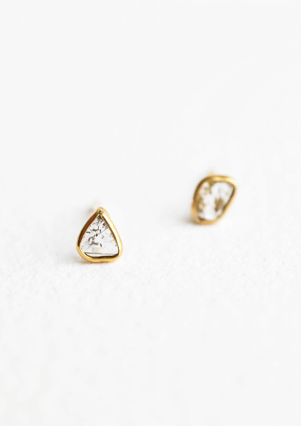 2: Organically shaped stud earrings with small diamond slice surrounded by brass metal trim
