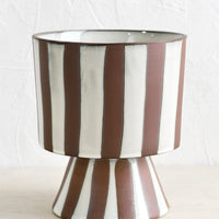 2: A brown and white striped footed planter.