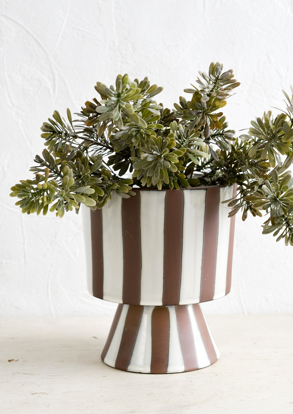 1: A striped ceramic planter with faux sedum plant.