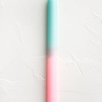 Mint / Pink: A straight taper candle in mint and pink.