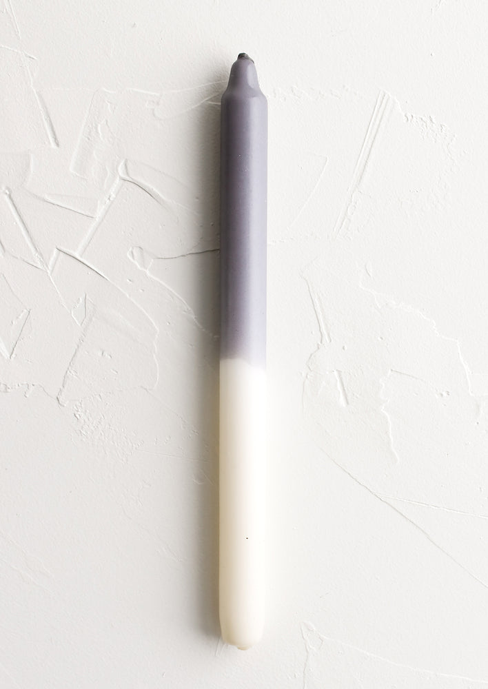A straight taper candle in grey and white.