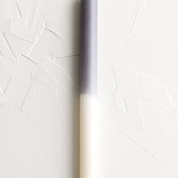 Ivory / Dark Grey: A straight taper candle in grey and white.