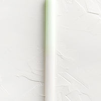 Ivory / Lime: A straight taper candle in lime and white.
