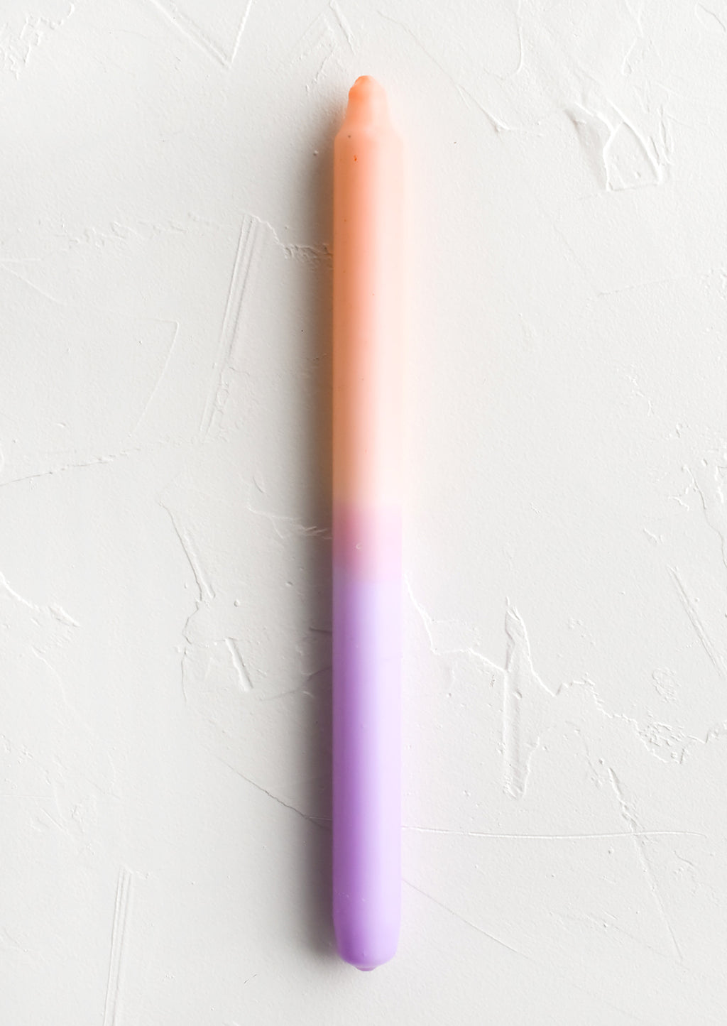 Peach / Lilac: A straight taper candle in peach and lilac.