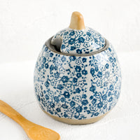 2: A blue floral ceramic sugar pot with wooden spoon