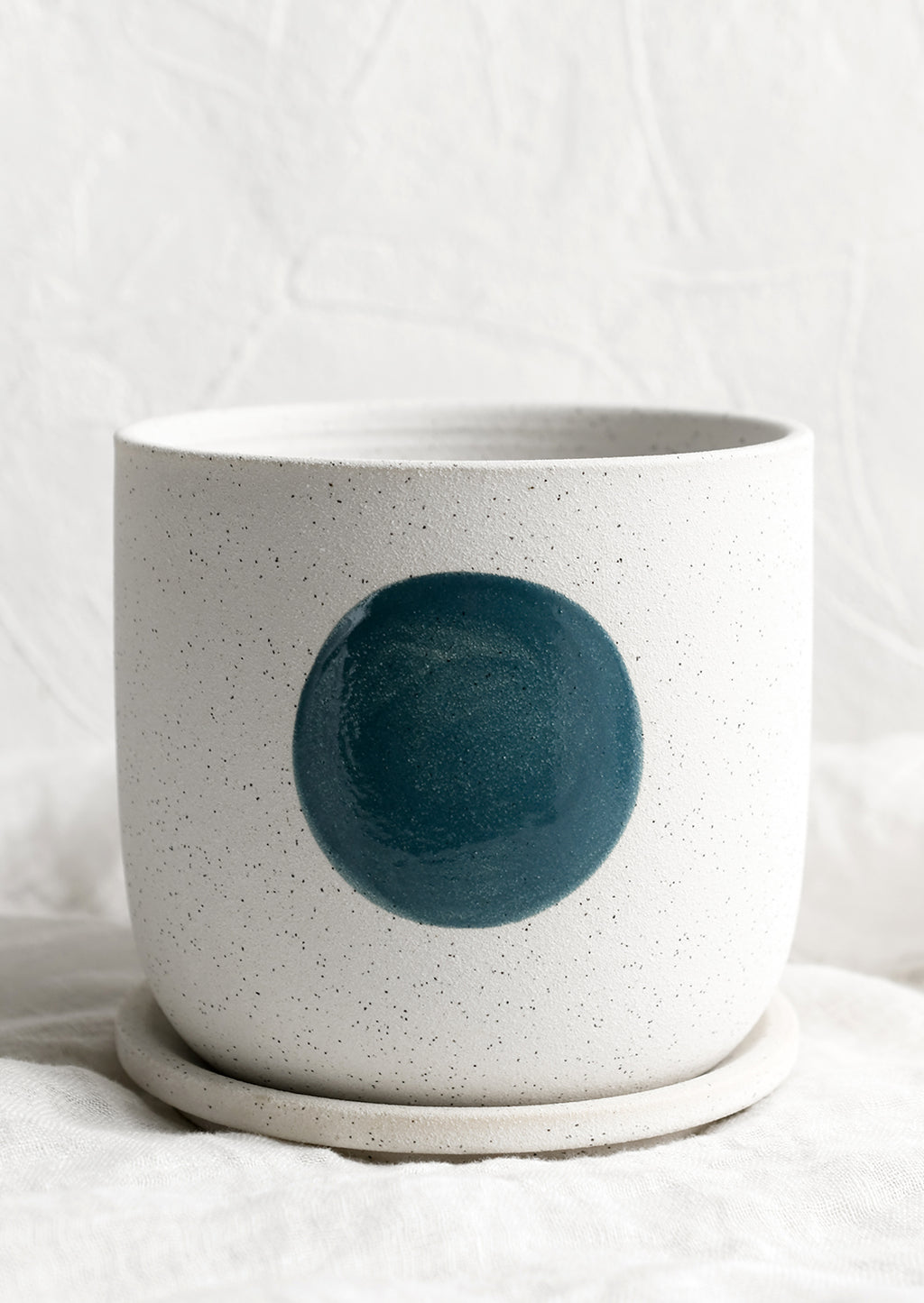 1: A white ceramic planter with blue dot.