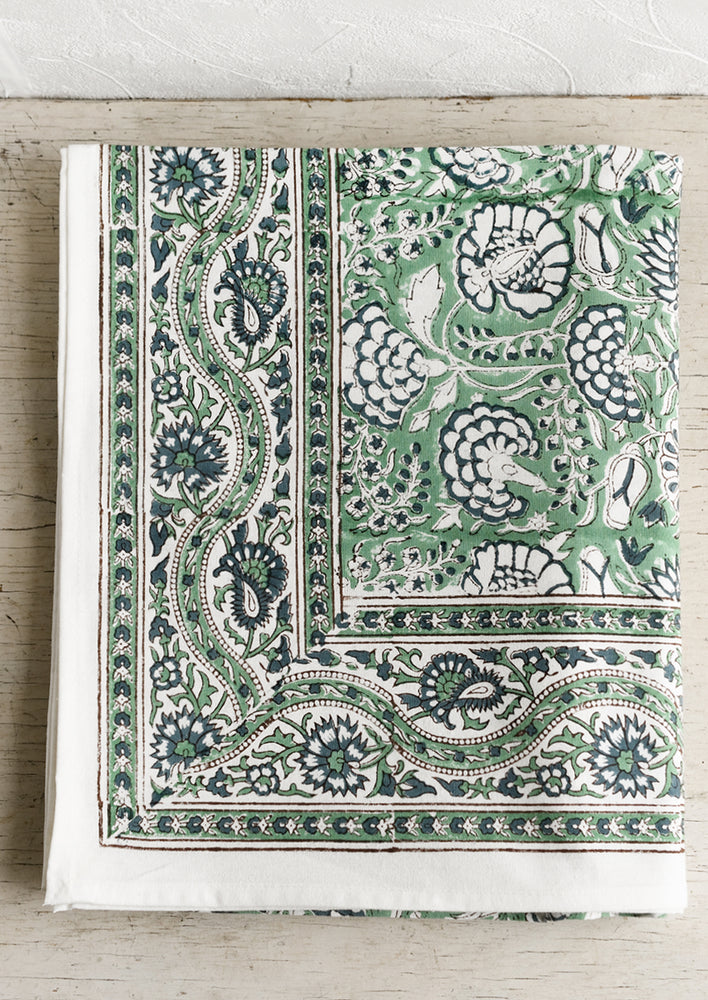 A block printed tablecloth with traditional print in blue and green shades.