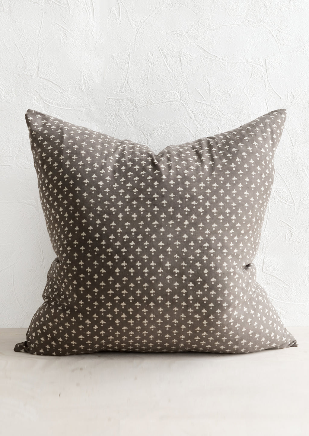 2: A square block printed throw pillow in dark grey with white dot-cross motif.