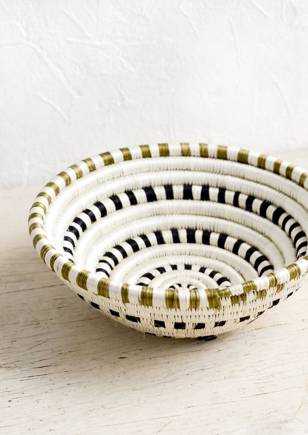 3: A sweetgrass basket in black and white dash pattern.