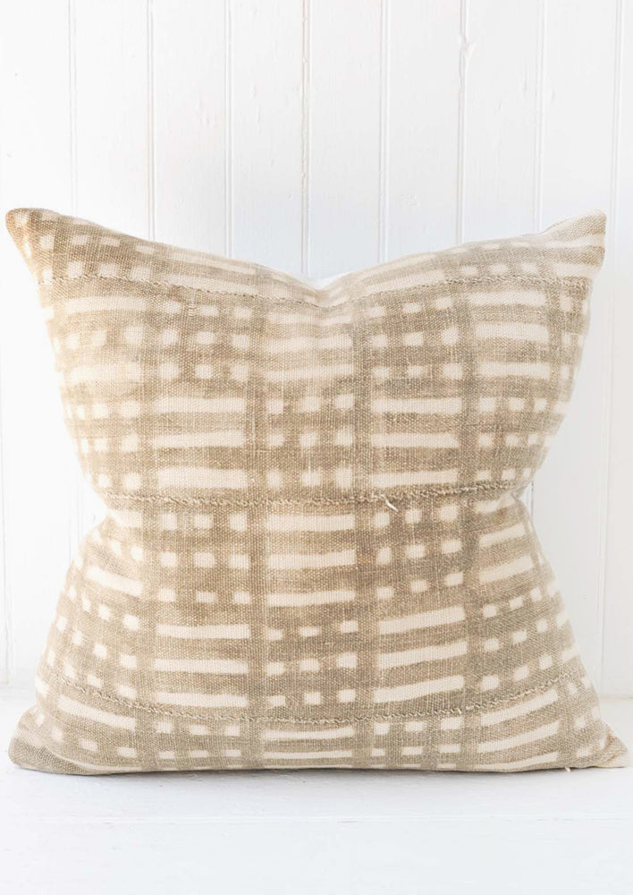 A patterned mudcloth pillow in aged grey.