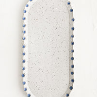 Glossy White Speckle / Blue: An oblong, oval shaped ceramic platter with blue dot imprint border.