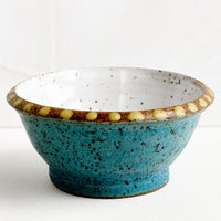 Galapagos / Ochre: A small turquoise ceramic bowl with yellow dot painted detailing.