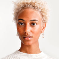 4: Model wears gold hoop earrings and cream colored sweater.