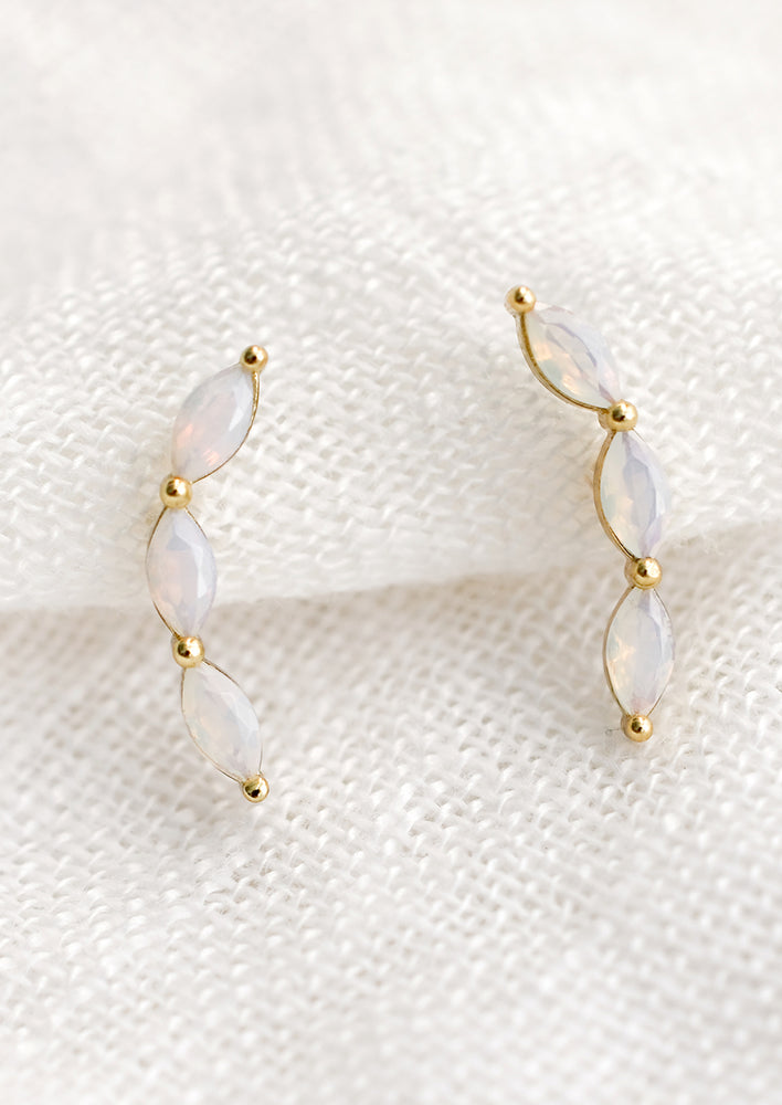 A pair of opal climber studs with three marquis stones.