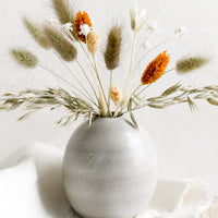 3: A bud vase holding dried flower arrangement.