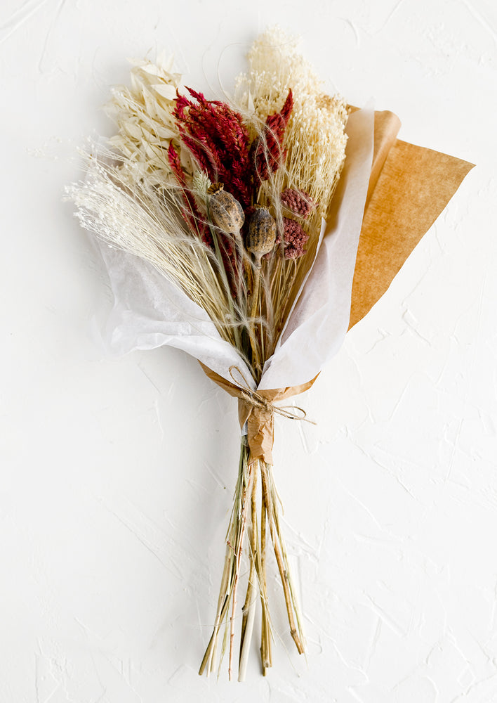 A dried floral bouquet in tones of ivory and red.