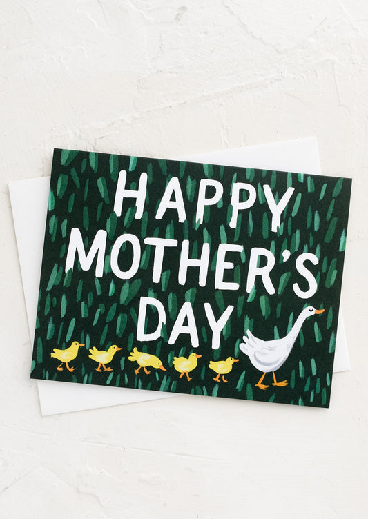 A greeting card with adult duck leading a row of baby ducks.