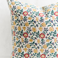 2: A block printed pillow in green, red, blue and yellow floral print.
