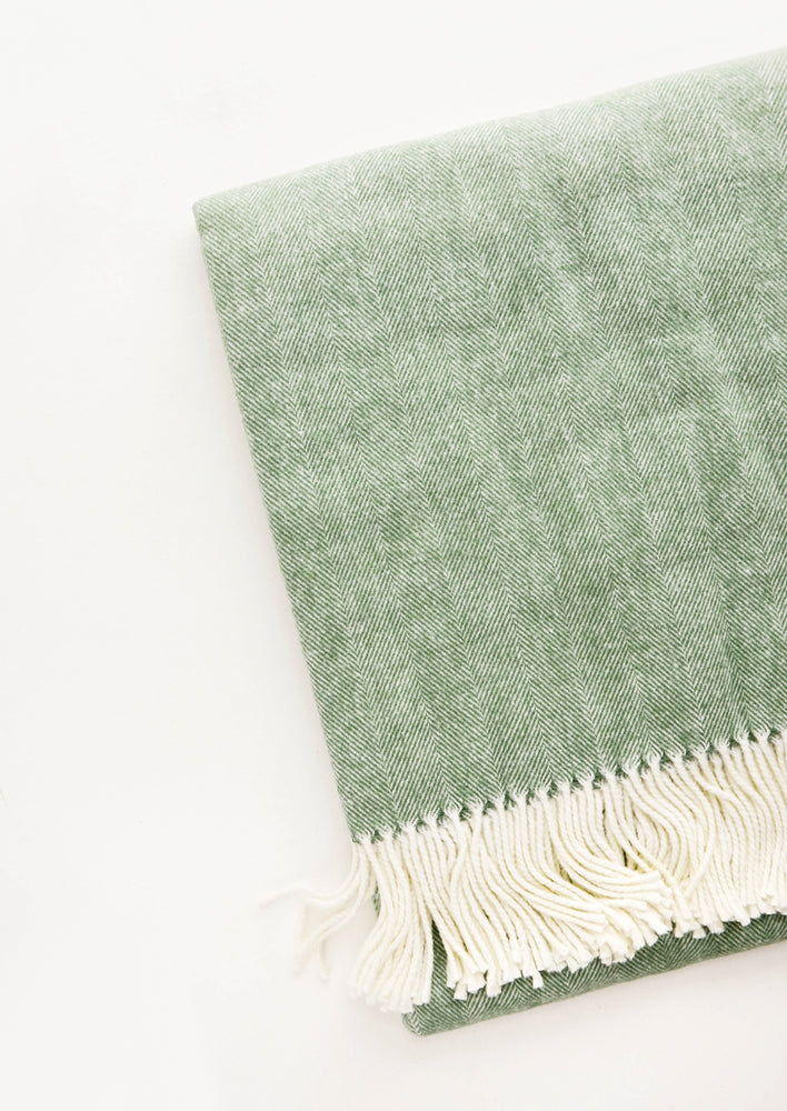 Olive: Green throw blanket in fine herringbone weave and ivory tassel trim